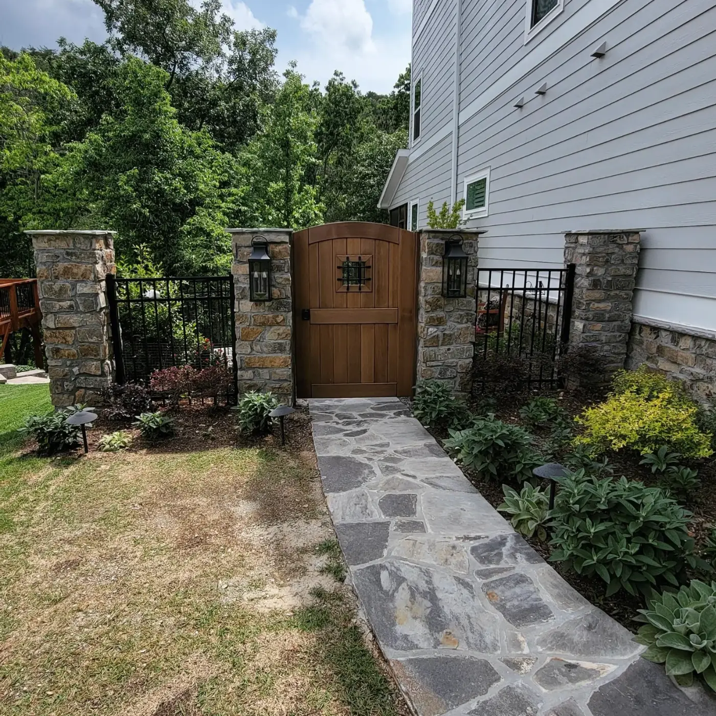 Arched cedar entry gate between stone pillars
