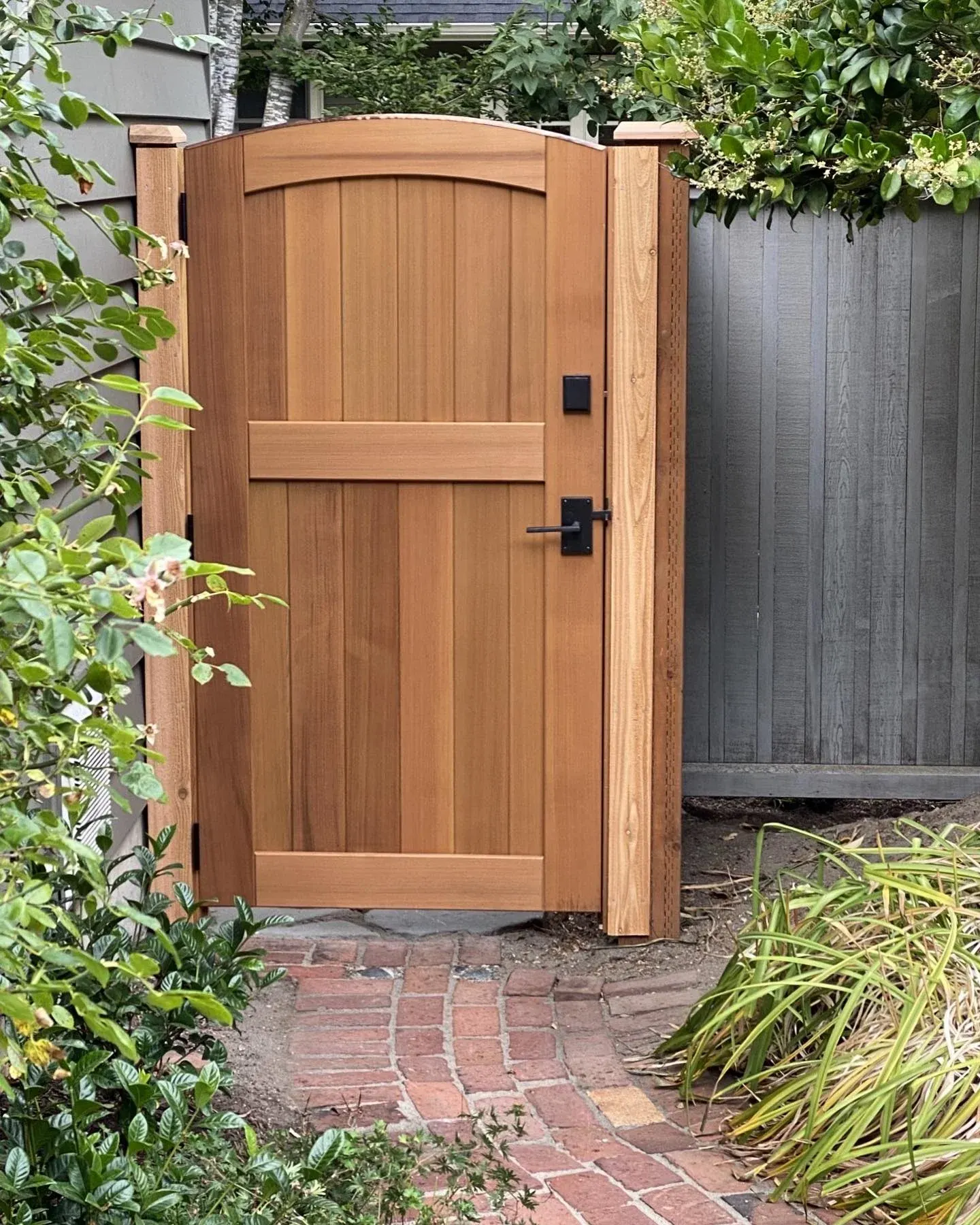 Custom cedar garden gate framed by landscaping