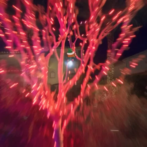 The elf airborne over a lit neighborhood